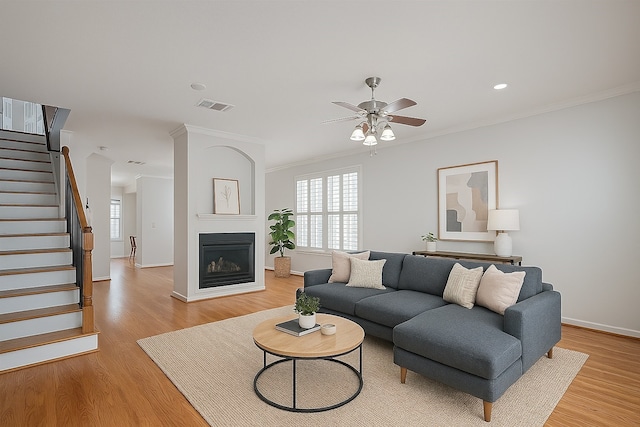 1108 W 22nd St, Houston, TX 77008 - living area featuring ceiling fan, stairway, light wood finished floors, baseboards, and crown molding