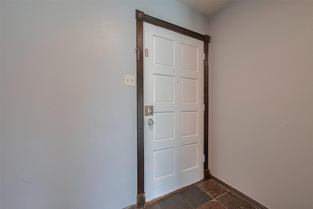 19531 Lazy Valley Dr, Katy, TX 77449 - doorway to outside featuring baseboards and dark stone finish flooring