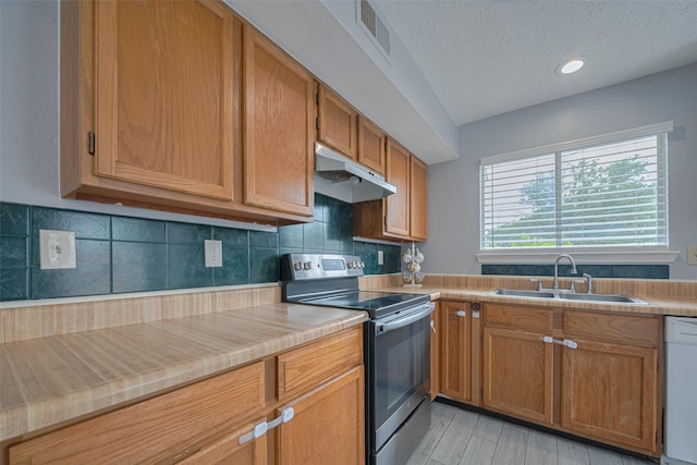 19531 Lazy Valley Dr, Katy, TX 77449 - kitchen featuring stainless steel electric range oven, a sink, under cabinet range hood, white dishwasher, and a textured ceiling