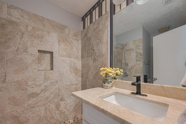 19531 Lazy Valley Dr, Katy, TX 77449 - bathroom with vanity, a tile shower, and a textured ceiling