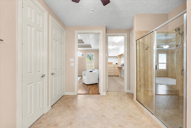 3707 Charleston St, Houston, TX 77021 - bathroom featuring a shower stall, a ceiling fan, tile patterned flooring, a textured ceiling, and baseboards