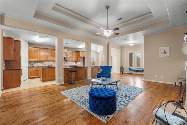 3707 Charleston St, Houston, TX 77021 - living room with ornamental molding, a raised ceiling, light wood-style floors, and ceiling fan