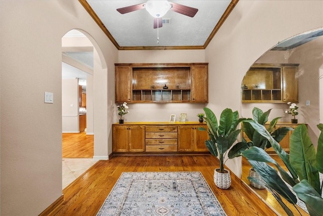 3707 Charleston St, Houston, TX 77021 - bar with arched walkways, crown molding, ceiling fan, and wood finished floors