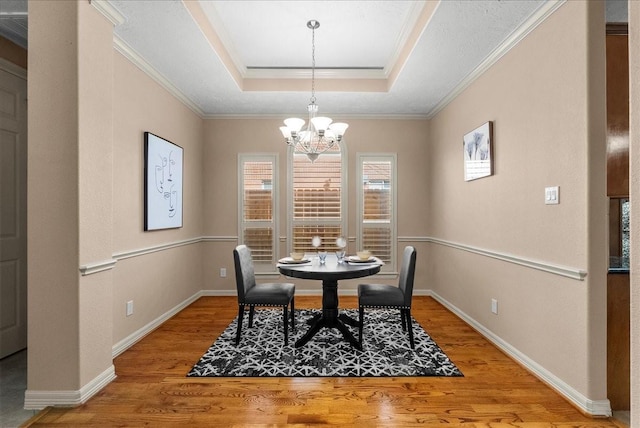 3707 Charleston St, Houston, TX 77021 - dining room with a tray ceiling, a chandelier, light wood-style flooring, crown molding, and baseboards