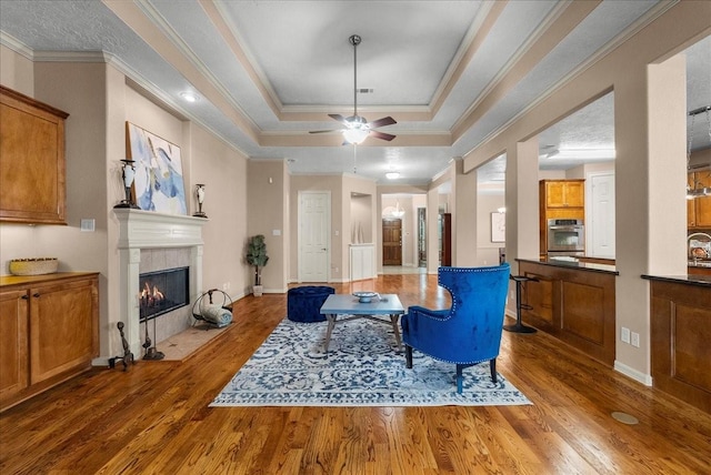 3707 Charleston St, Houston, TX 77021 - living area with wood finished floors, a fireplace, a ceiling fan, a raised ceiling, and crown molding