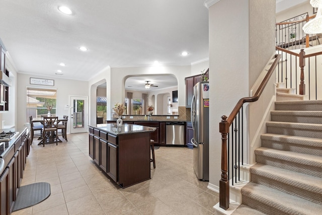 2153 Summit Mist Dr, Conroe, TX 77304 - kitchen with appliances with stainless steel finishes, arched walkways, dark brown cabinetry, a sink, and recessed lighting