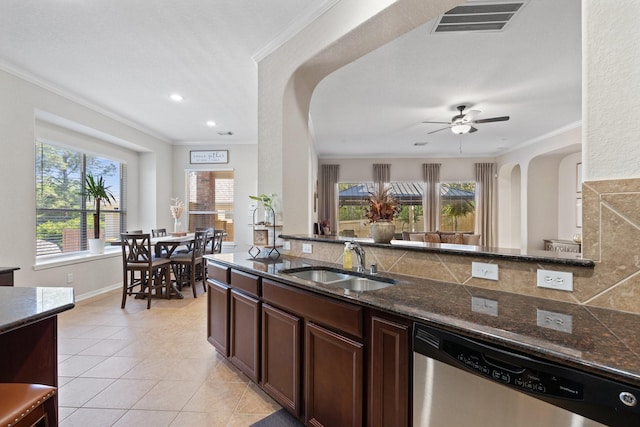 2153 Summit Mist Dr, Conroe, TX 77304 - kitchen featuring dishwasher, a sink, arched walkways, light tile patterned floors, and plenty of natural light