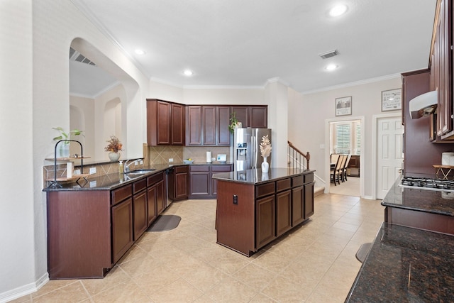 2153 Summit Mist Dr, Conroe, TX 77304 - kitchen featuring stainless steel appliances, a center island, a sink, decorative backsplash, and dark stone countertops