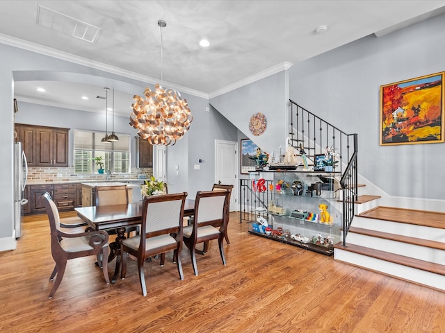 1616 Rosewood St, Houston, TX 77004 - dining space featuring light wood-type flooring, stairway, ornamental molding, a chandelier, and recessed lighting