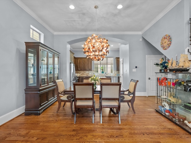 1616 Rosewood St, Houston, TX 77004 - dining space featuring arched walkways, a chandelier, ornamental molding, light wood-style floors, and recessed lighting