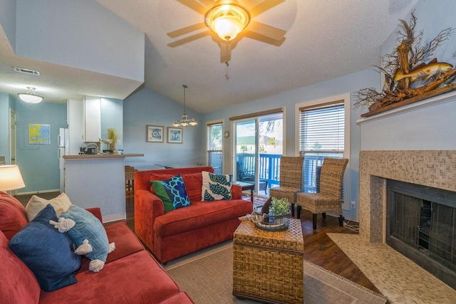 14434 E Cabana St Unit 319, Corpus Christi, TX 78418 - living area featuring wood finished floors, lofted ceiling, a tiled fireplace, a ceiling fan, and a chandelier