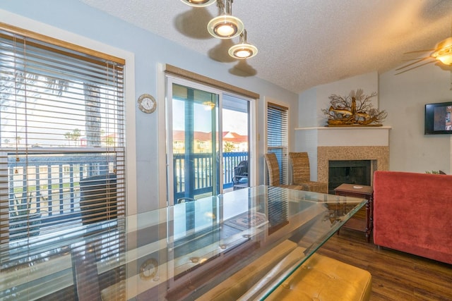 14434 E Cabana St Unit 319, Corpus Christi, TX 78418 - dining space featuring a textured ceiling, wood finished floors, a fireplace, a ceiling fan, and lofted ceiling