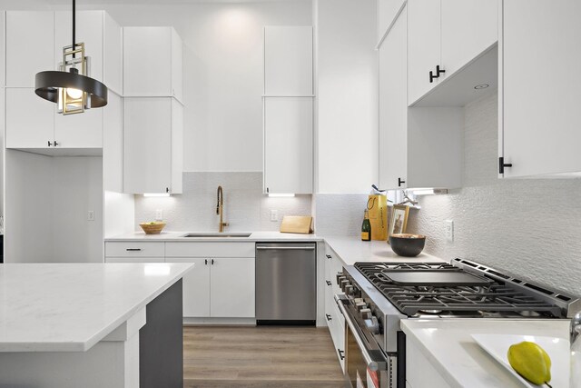 11120 Savannah Woods Ln, Houston, TX 77043 - kitchen with appliances with stainless steel finishes, a sink, white cabinetry, and decorative backsplash