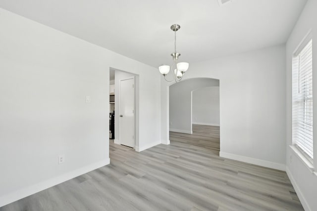 2707 Shawna Lyn Dr, Spring, TX 77373 - unfurnished room with arched walkways, light wood-style flooring, and a chandelier