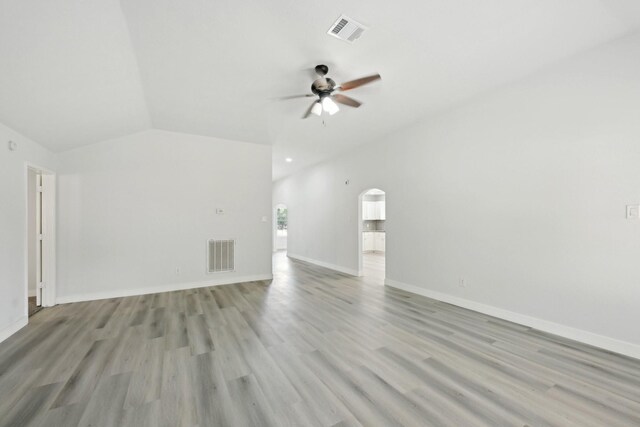 2707 Shawna Lyn Dr, Spring, TX 77373 - unfurnished living room featuring a ceiling fan, vaulted ceiling, arched walkways, and light wood-type flooring