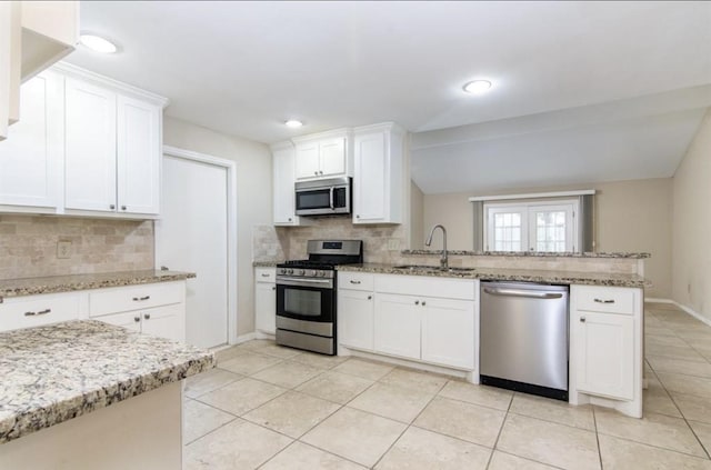 5807 Silver Forest Dr, Houston, TX 77092 - kitchen featuring stainless steel appliances, a peninsula, backsplash, light tile patterned flooring, and white cabinetry