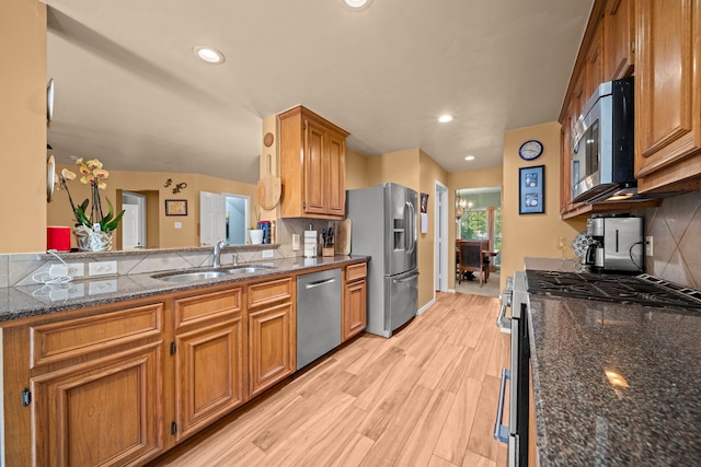 2223 Caroline Park Ln, Spring, TX 77386 - kitchen featuring appliances with stainless steel finishes, a sink, tasteful backsplash, light wood-type flooring, and recessed lighting