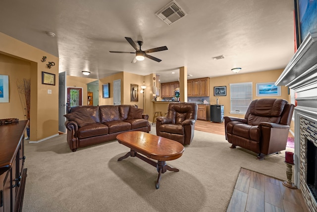 2223 Caroline Park Ln, Spring, TX 77386 - living area with a fireplace, a ceiling fan, baseboards, and light carpet