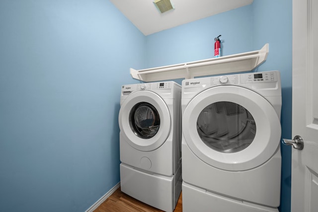 2223 Caroline Park Ln, Spring, TX 77386 - washroom featuring washing machine and clothes dryer, wood finished floors, and baseboards