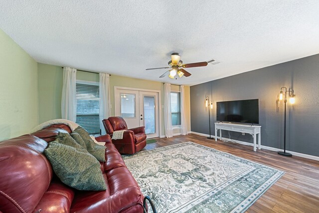 6506 Kentwick Dr, Houston, TX 77084 - living room featuring a textured ceiling, wood finished floors, healthy amount of natural light, ceiling fan, and french doors