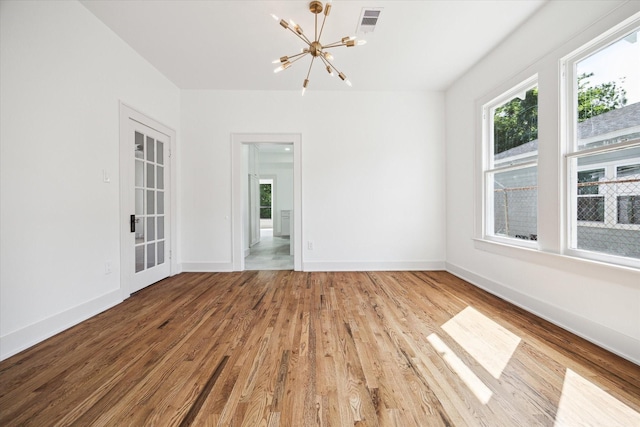 1546 Lawson St, Houston, TX 77023 - unfurnished room featuring a chandelier, wood finished floors, and baseboards