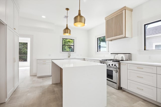 1546 Lawson St, Houston, TX 77023 - kitchen with stainless steel range, a center island, light countertops, a sink, and pendant lighting