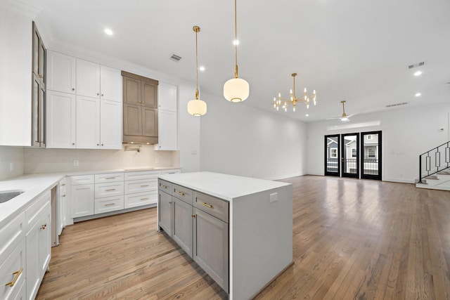 1013 E 28th St, Houston, TX 77009 - kitchen featuring light wood-style flooring, gray cabinetry, a chandelier, recessed lighting, and light countertops
