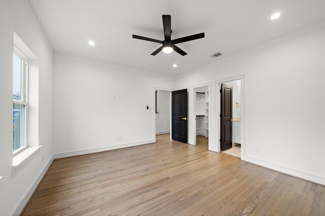 1013 E 28th St, Houston, TX 77009 - unfurnished bedroom with light wood-type flooring, recessed lighting, baseboards, a spacious closet, and ensuite bathroom