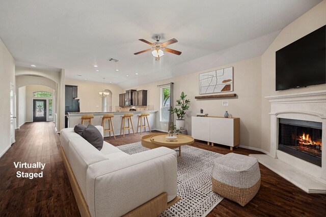 122 Jacobs Meadow Dr, Conroe, TX 77384 - living area featuring ceiling fan, wood finished floors, arched walkways, a warm lit fireplace, and recessed lighting