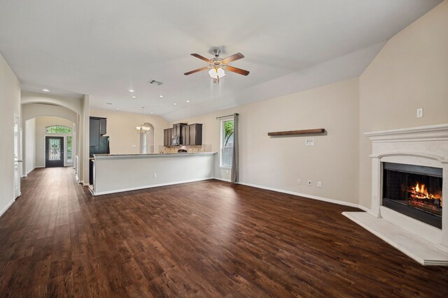122 Jacobs Meadow Dr, Conroe, TX 77384 - unfurnished living room featuring ceiling fan, a warm lit fireplace, dark wood-type flooring, arched walkways, and baseboards