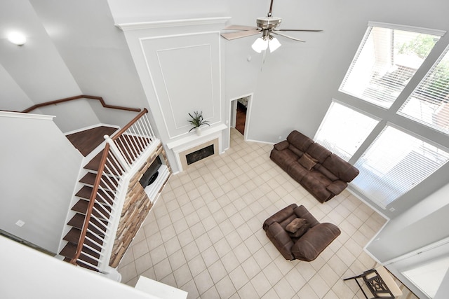 8742 Melting Shadows Ln, Houston, TX 77095 - unfurnished living room with ceiling fan, a towering ceiling, a fireplace, tile patterned flooring, and baseboards