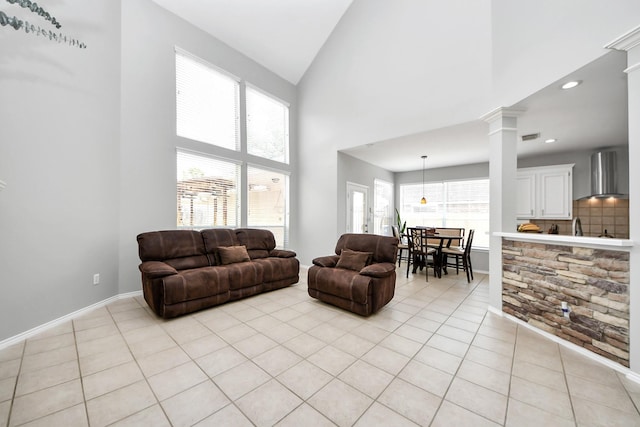 8742 Melting Shadows Ln, Houston, TX 77095 - living room with light tile patterned floors, high vaulted ceiling, ornate columns, and baseboards
