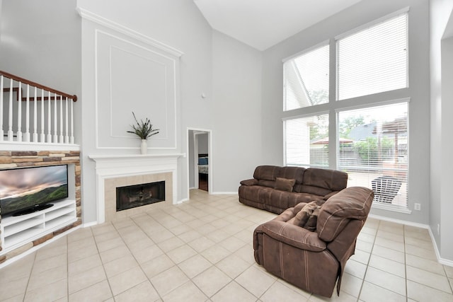 8742 Melting Shadows Ln, Houston, TX 77095 - living room featuring a tile fireplace, light tile patterned floors, high vaulted ceiling, and baseboards