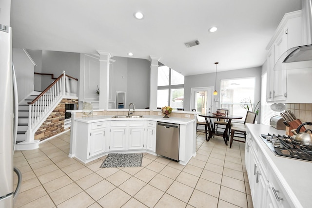 8742 Melting Shadows Ln, Houston, TX 77095 - kitchen with stainless steel appliances, a sink, light countertops, wall chimney exhaust hood, and ornate columns
