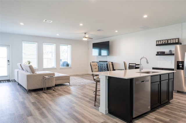 12327 Brandenburg Gate Dr, Houston, TX 77047 - kitchen with appliances with stainless steel finishes, a sink, open floor plan, light countertops, and an island with sink