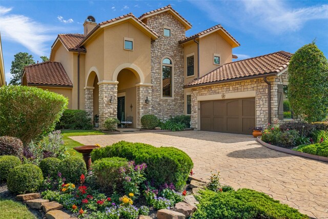 16119 Villa Fontana Way, Houston, TX 77068 - mediterranean / spanish home featuring stone siding, stucco siding, a garage, and a chimney