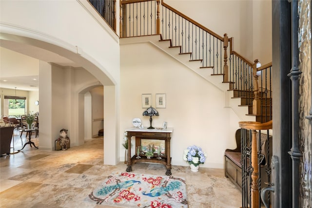 16119 Villa Fontana Way, Houston, TX 77068 - foyer featuring arched walkways, a towering ceiling, stairs, and stone finish floors
