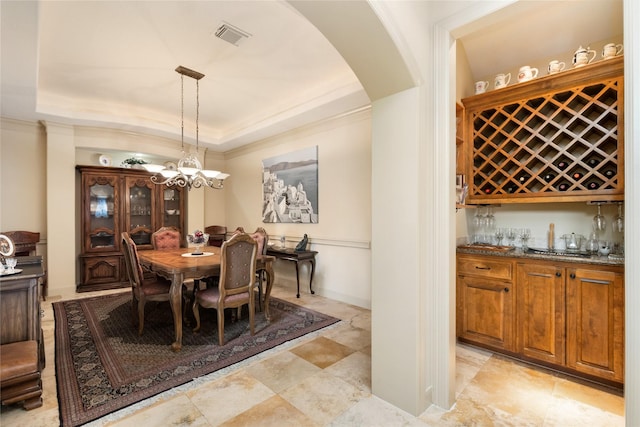 16119 Villa Fontana Way, Houston, TX 77068 - dining area featuring arched walkways, a raised ceiling, wet bar, crown molding, and a chandelier