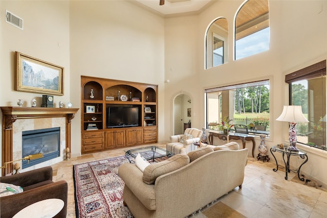 16119 Villa Fontana Way, Houston, TX 77068 - living room with a high ceiling, a tiled fireplace, crown molding, and arched walkways