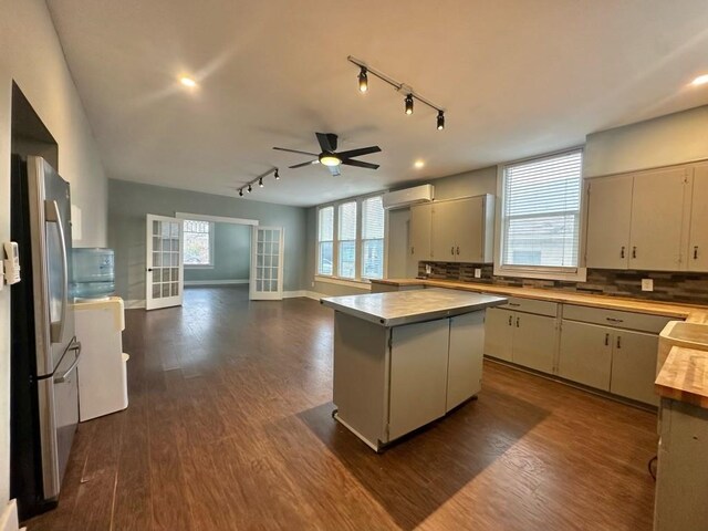 236 8th St, Somerville, TX 77879 - kitchen with track lighting, freestanding refrigerator, dark wood finished floors, a ceiling fan, and backsplash