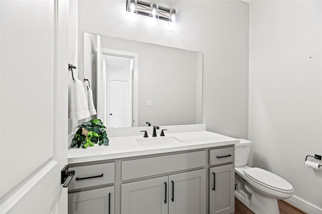 12011 Royal Oaks Run Dr, Houston, TX 77082 - half bath with toilet, vanity, wood finished floors, and baseboards