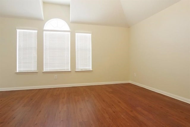 15415 Bammel Oaks Ct, Houston, TX 77014 - empty room with wood finished floors, vaulted ceiling, baseboards, and healthy amount of natural light