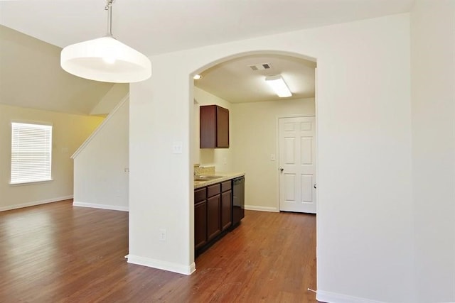 15415 Bammel Oaks Ct, Houston, TX 77014 - kitchen featuring dark wood finished floors, a sink, arched walkways, black dishwasher, and baseboards