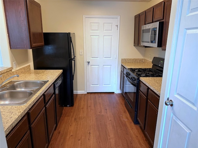 15415 Bammel Oaks Ct, Houston, TX 77014 - kitchen with black appliances, a sink, wood finished floors, and light countertops