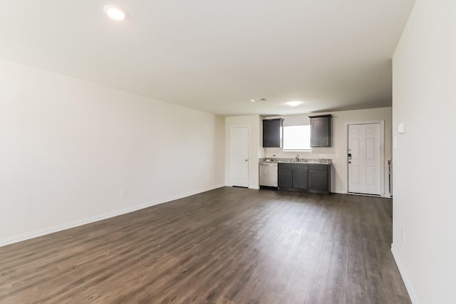 7945 Henson St, Houston, TX 77028 - unfurnished living room with dark wood finished floors, baseboards, and a sink