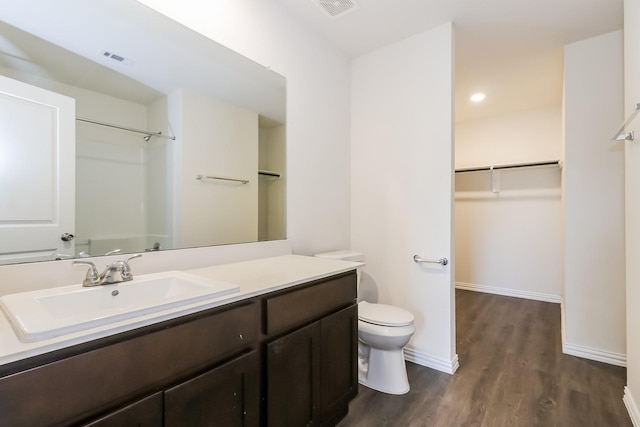 7945 Henson St, Houston, TX 77028 - full bathroom with wood finished floors, vanity, toilet, a spacious closet, and baseboards