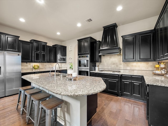 8322 Sands Bank Ln, Conroe, TX 77304 - kitchen with appliances with stainless steel finishes, dark cabinets, a sink, custom range hood, and recessed lighting
