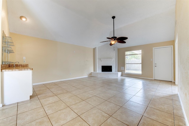 4035 Green Crst, Houston, TX 77082 - unfurnished living room with vaulted ceiling, ceiling fan, light tile patterned flooring, a fireplace, and a sink