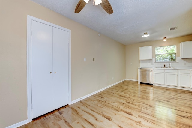4035 Green Crst, Houston, TX 77082 - unfurnished living room featuring a sink, light wood finished floors, ceiling fan, baseboards, and a textured ceiling