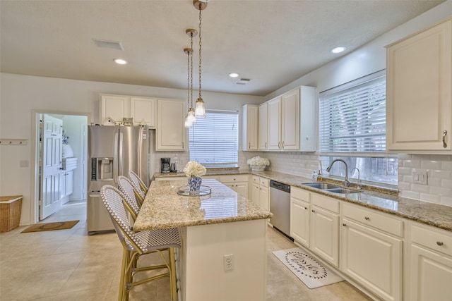 26 E Sterling Pond Cir, The Woodlands, TX 77382 - kitchen with stainless steel appliances, a sink, a center island, tasteful backsplash, and recessed lighting